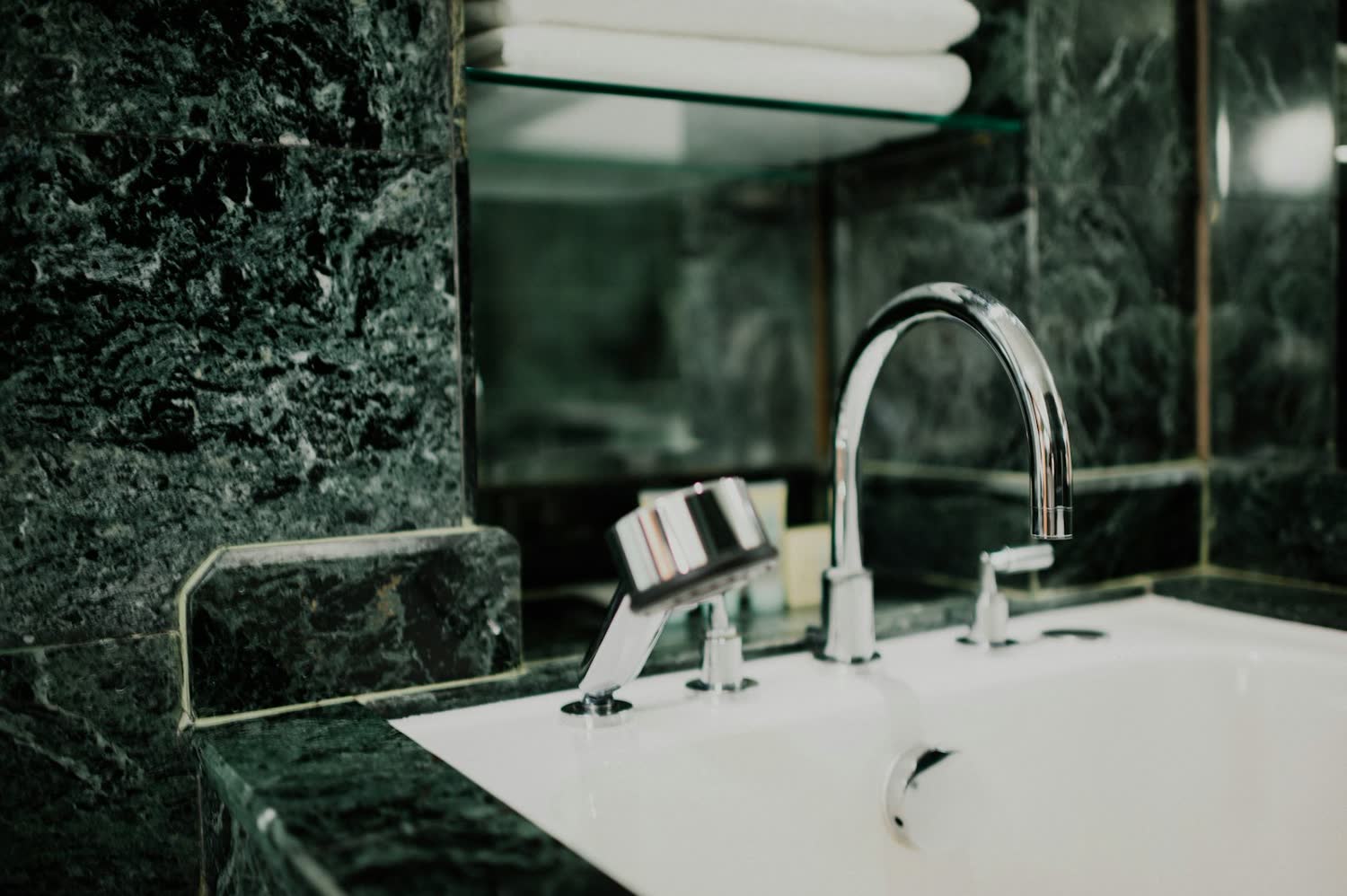 Green marble bathroom with a freestanding bath