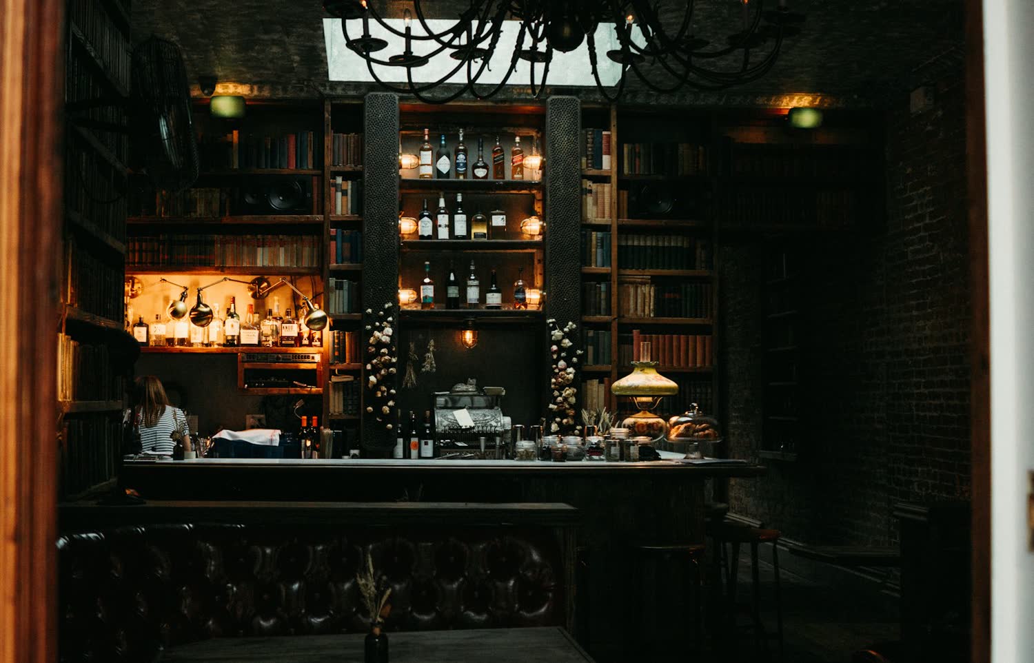 The bar at Salt and Iron, dark wood and bottle shelves