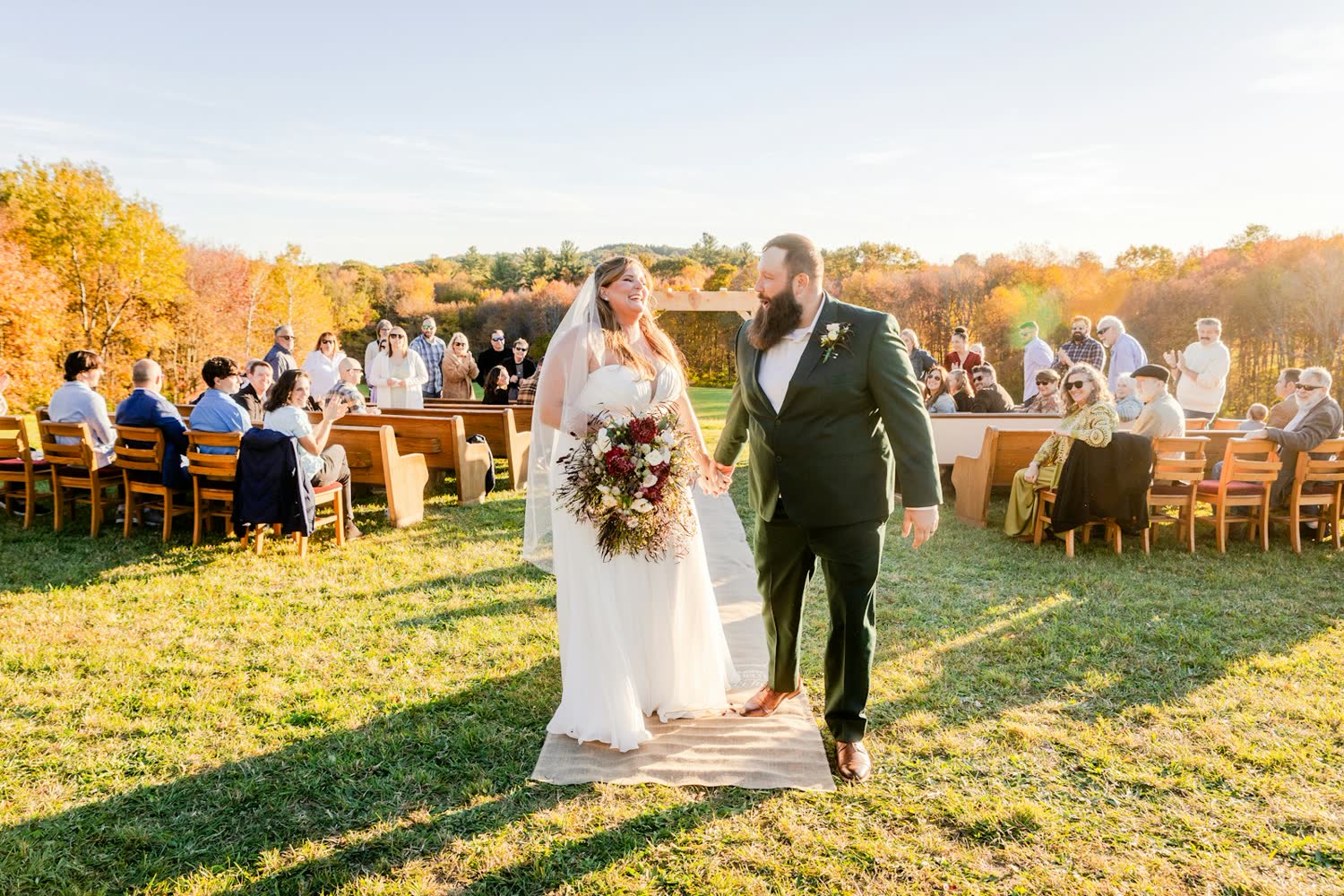 Couple walking through the reception as guests applaud