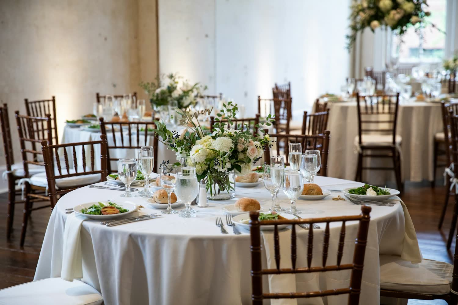 Round table laid with white flowers and linen