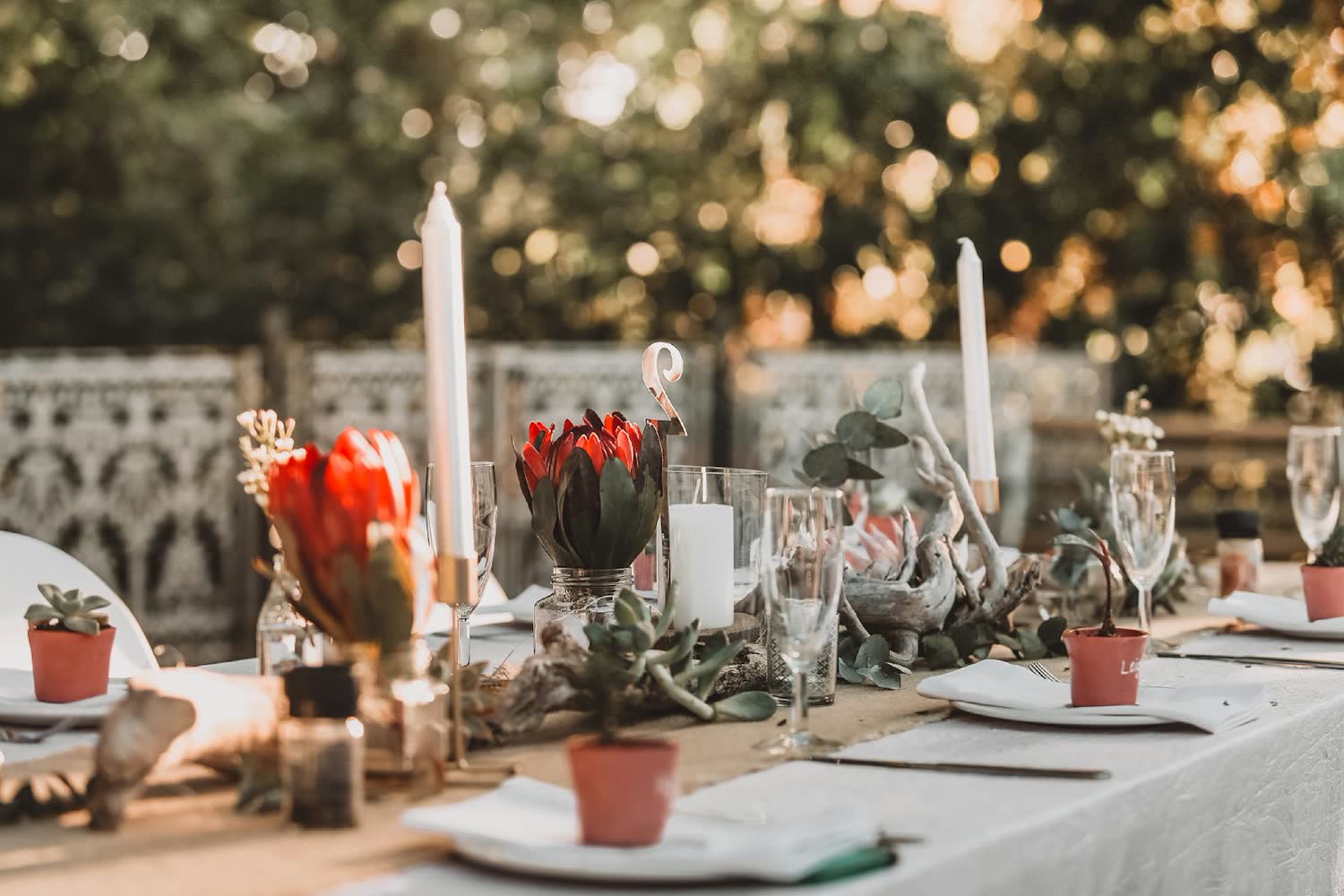 A long table laid with candles and foliage for the wedding breakfast